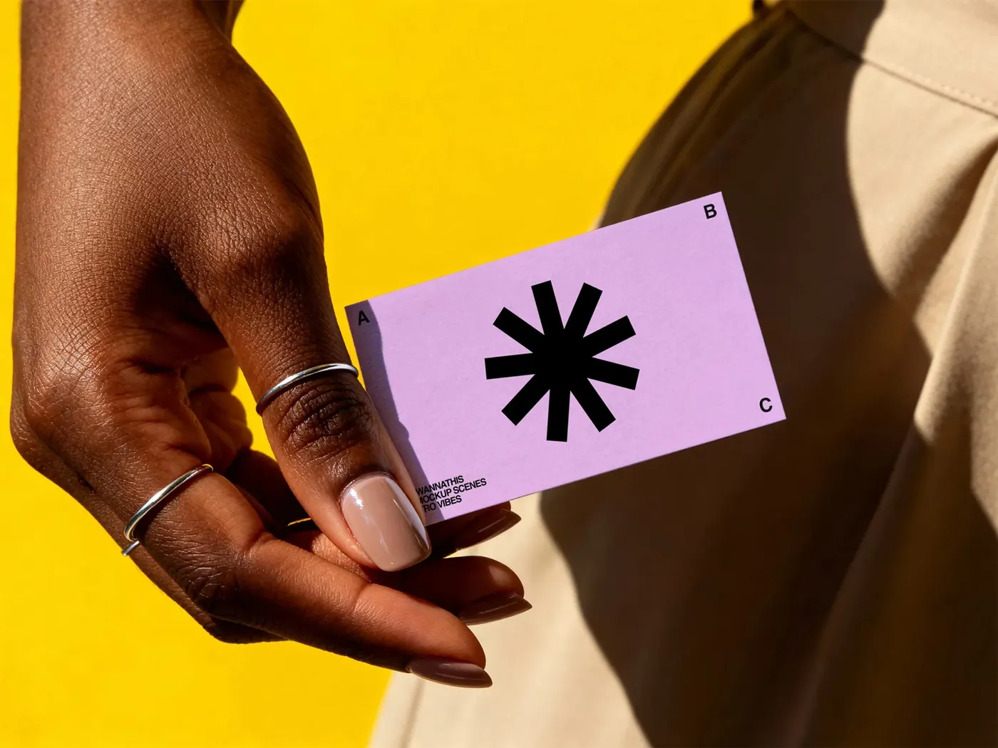 Printed brand card held in hand against a yellow background