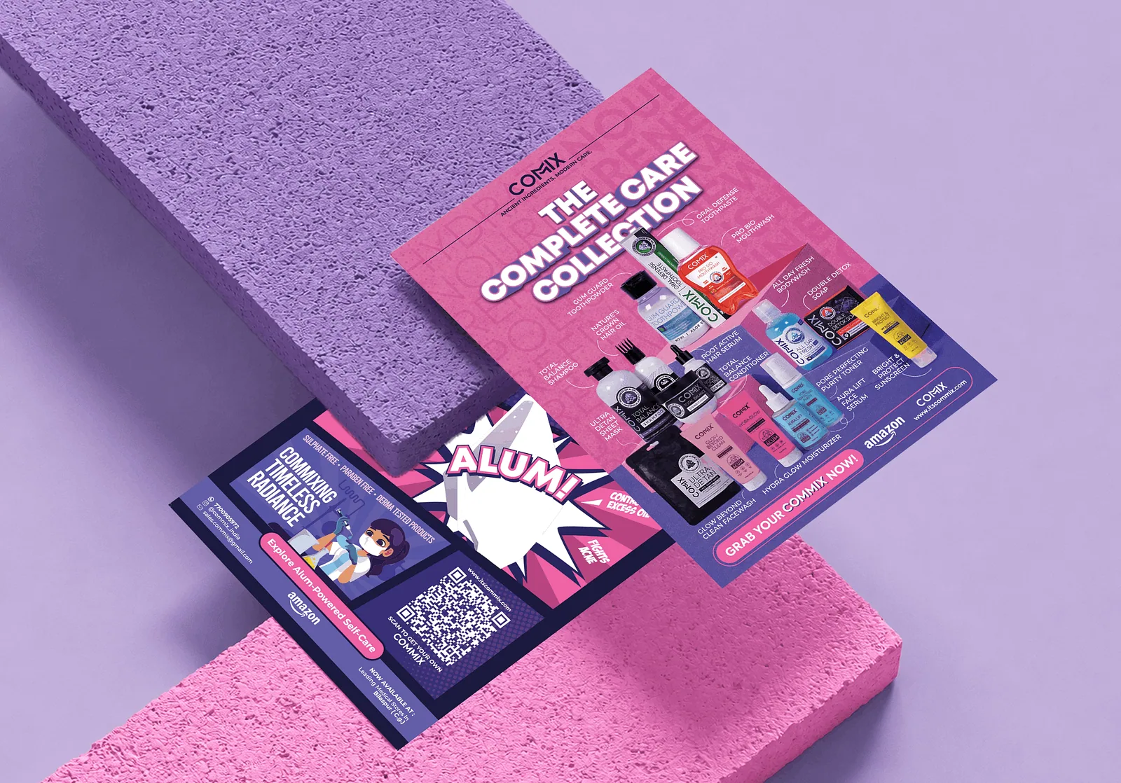 Two COMMIX flyers propped against lilac and pink foam blocks