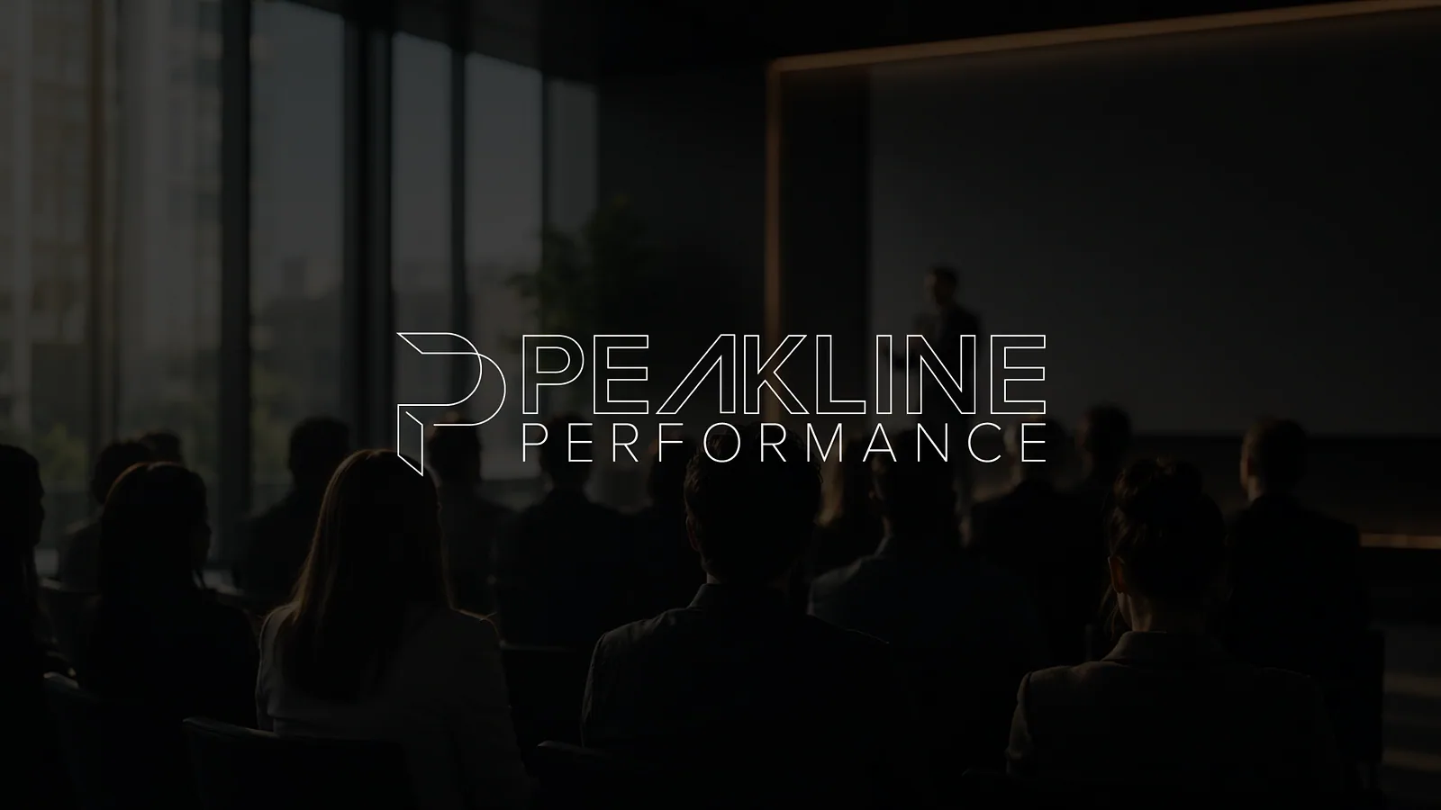 Peakline Performance wordmark reversed over a darkened auditorium photograph