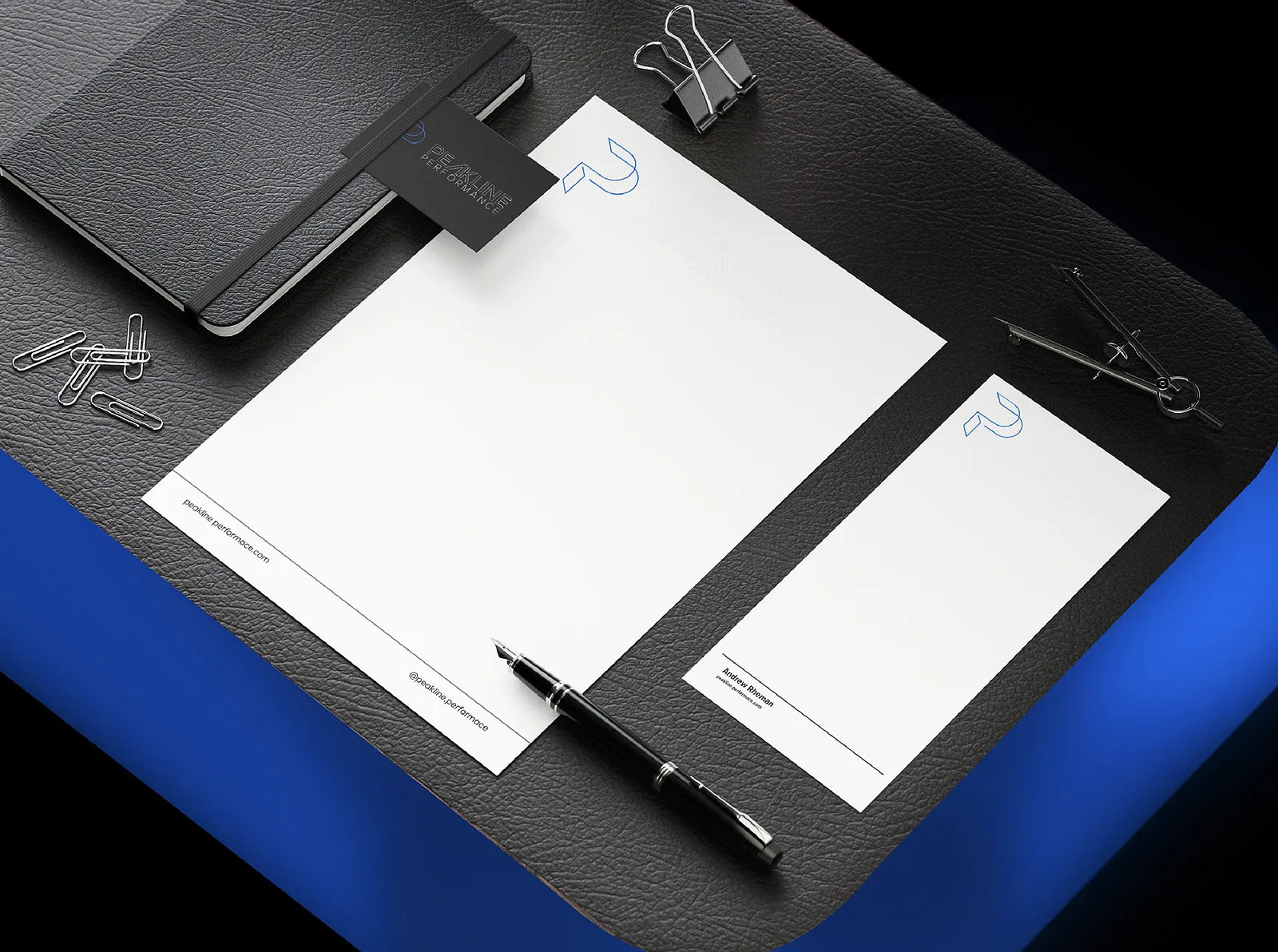 Stationery flat lay with letterhead, notebook and pen on blue leather