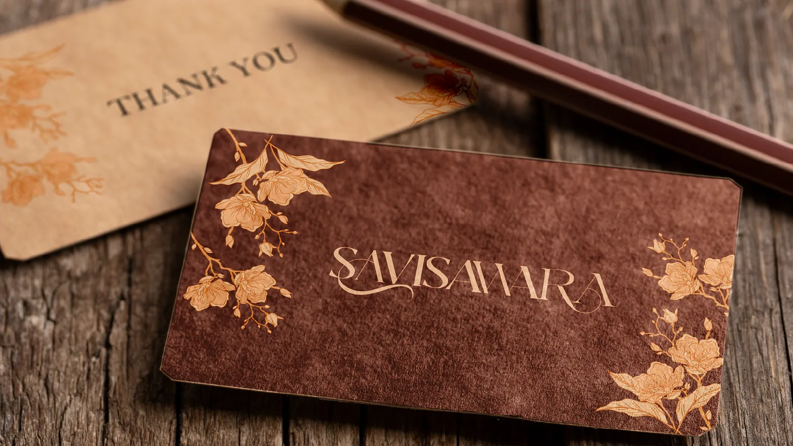 Gold foil business card with floral corners beside a thank-you card