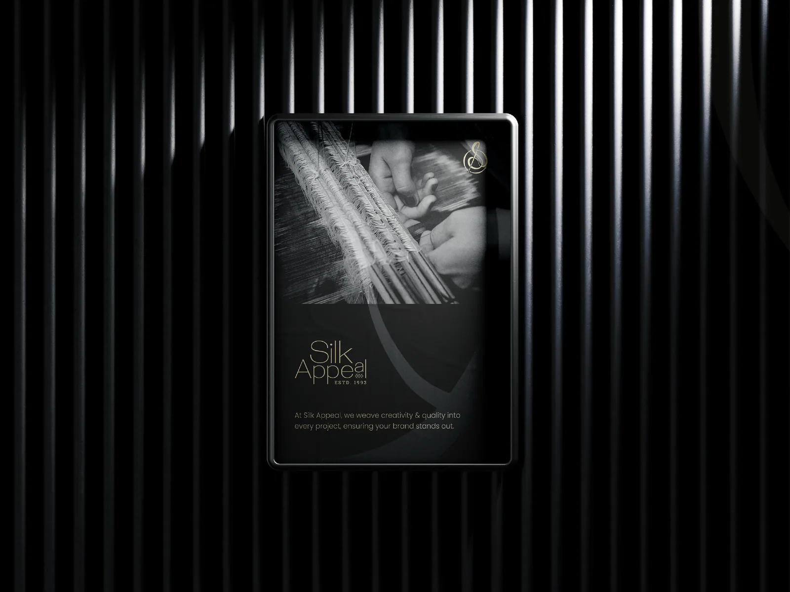 Tablet against a black fluted wall showing a dark brand page